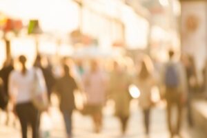 Blurred crowd walking outdoors in warm light.